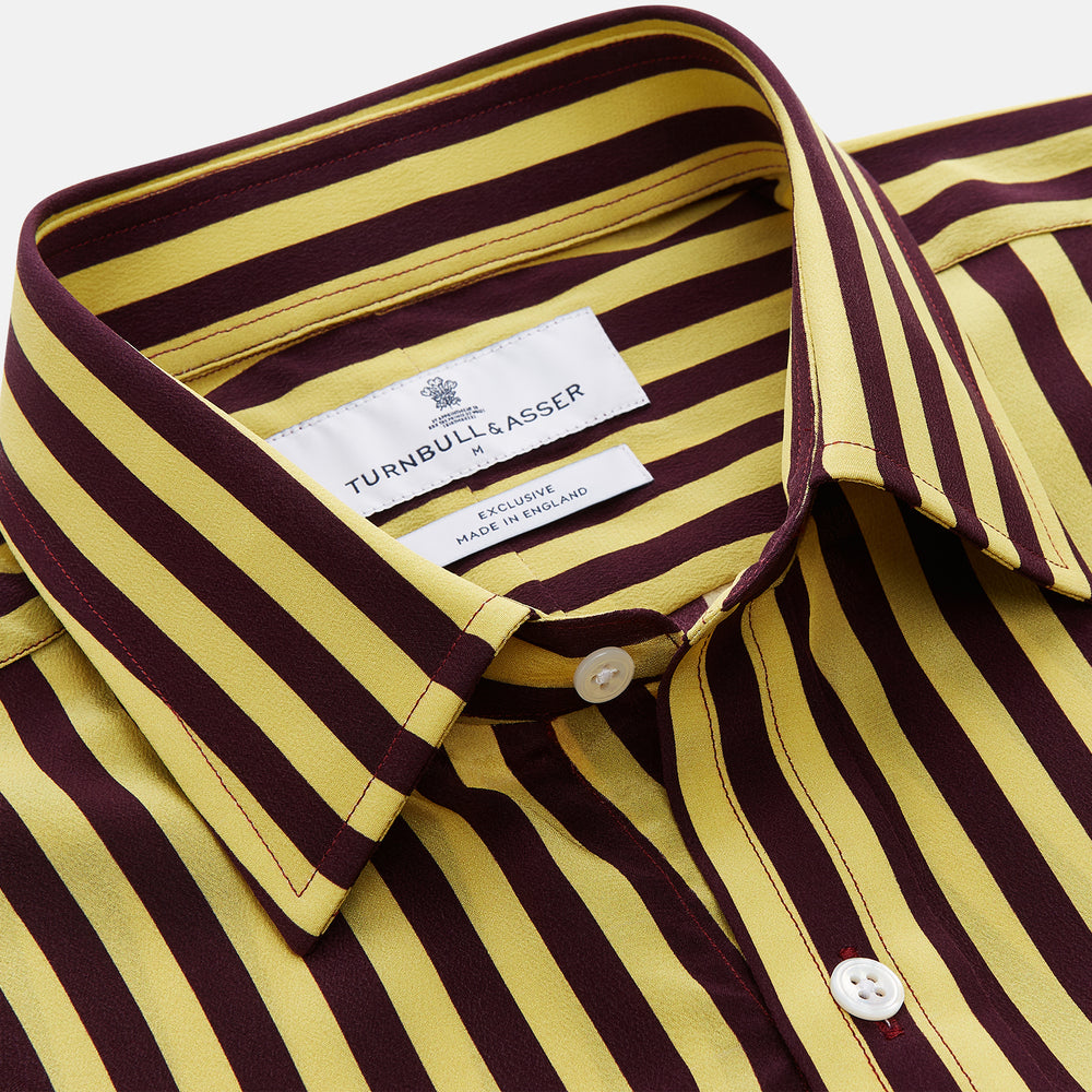 The Turnbull & Asser Yellow and Burgundy Candy Stripe Silk Weekend Fit Harold Shirt features long sleeves, a classic collar, white buttons, and a tailored design.