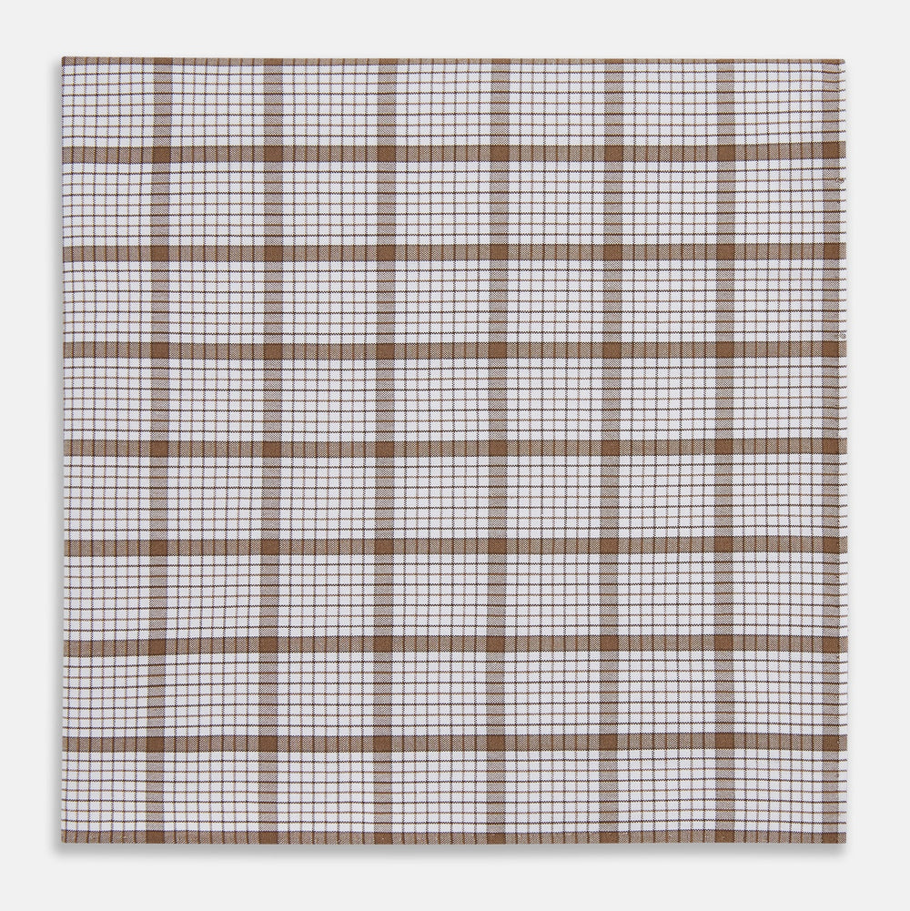 The Turnbull & Asser Hand Rolled Brown Overlay Check Handkerchief is a rectangular white cotton accessory with evenly spaced brown and black grid lines, forming squares—a timeless classic for gentlemen.