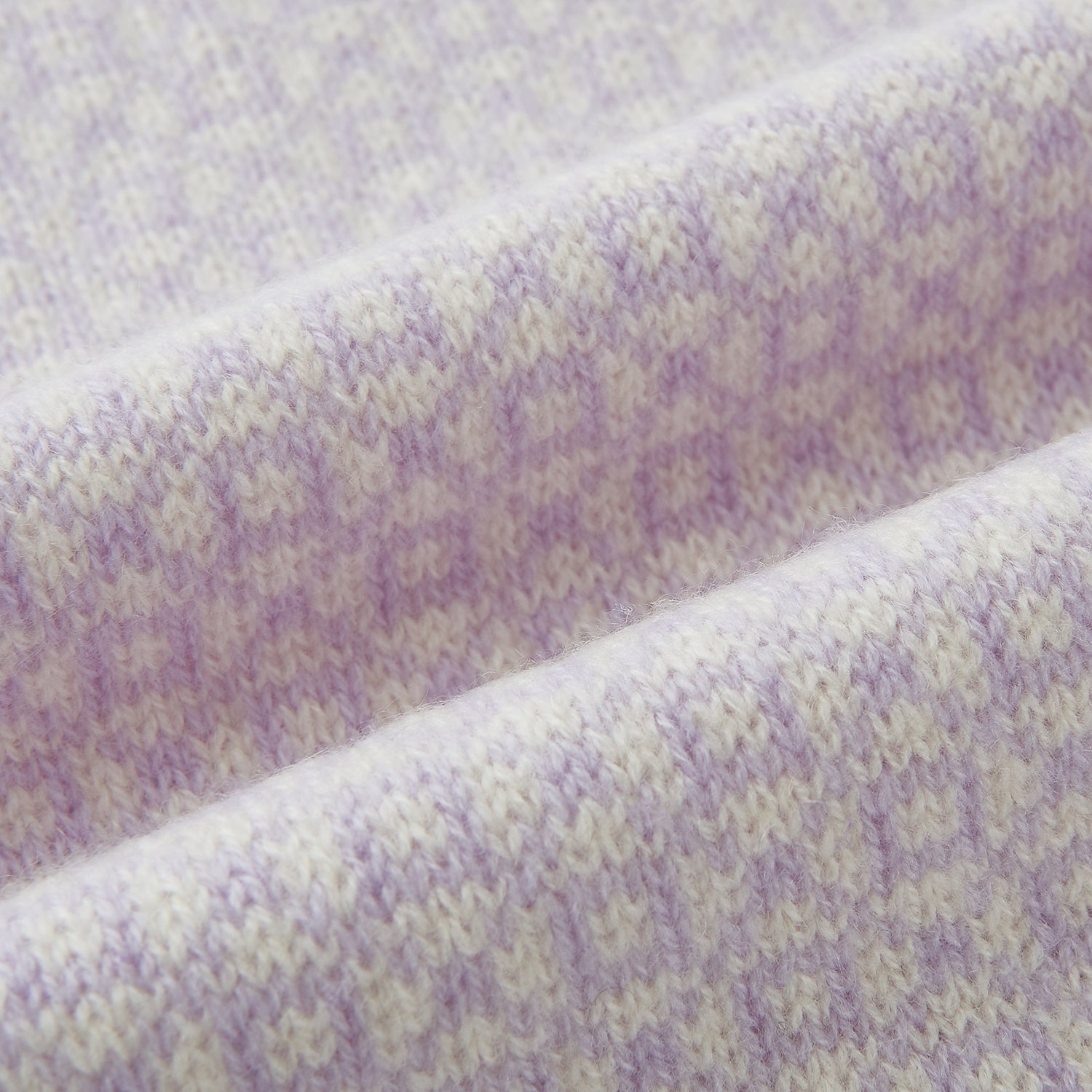 View 3 of product The Turnbull & Asser Ivory and Lilac Lozenge-Patterned Cashmere Knitted Scarf, tied loosely, reveals its refined style and geometric design against a plain white background.