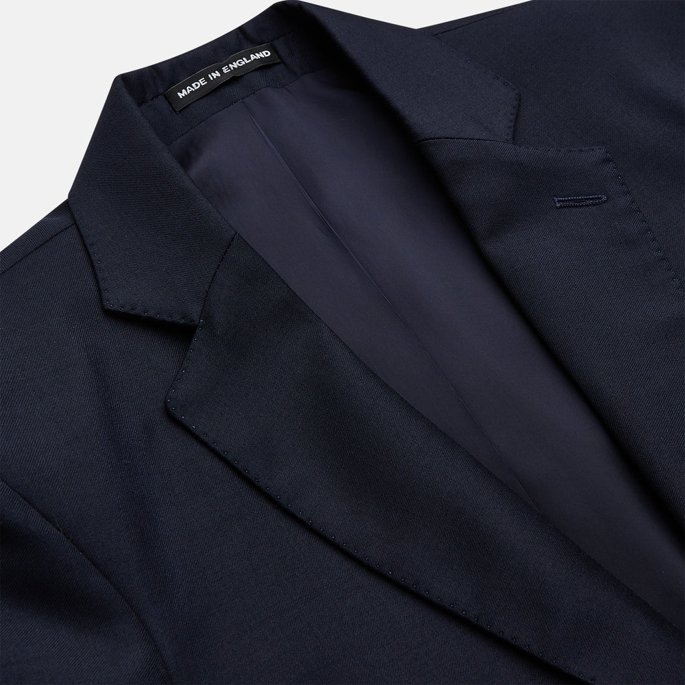 The Turnbull & Asser Navy Plain Wool Single Breasted Blazer features gold buttons, a notched lapel, and multiple pockets, and is shown against a white background.