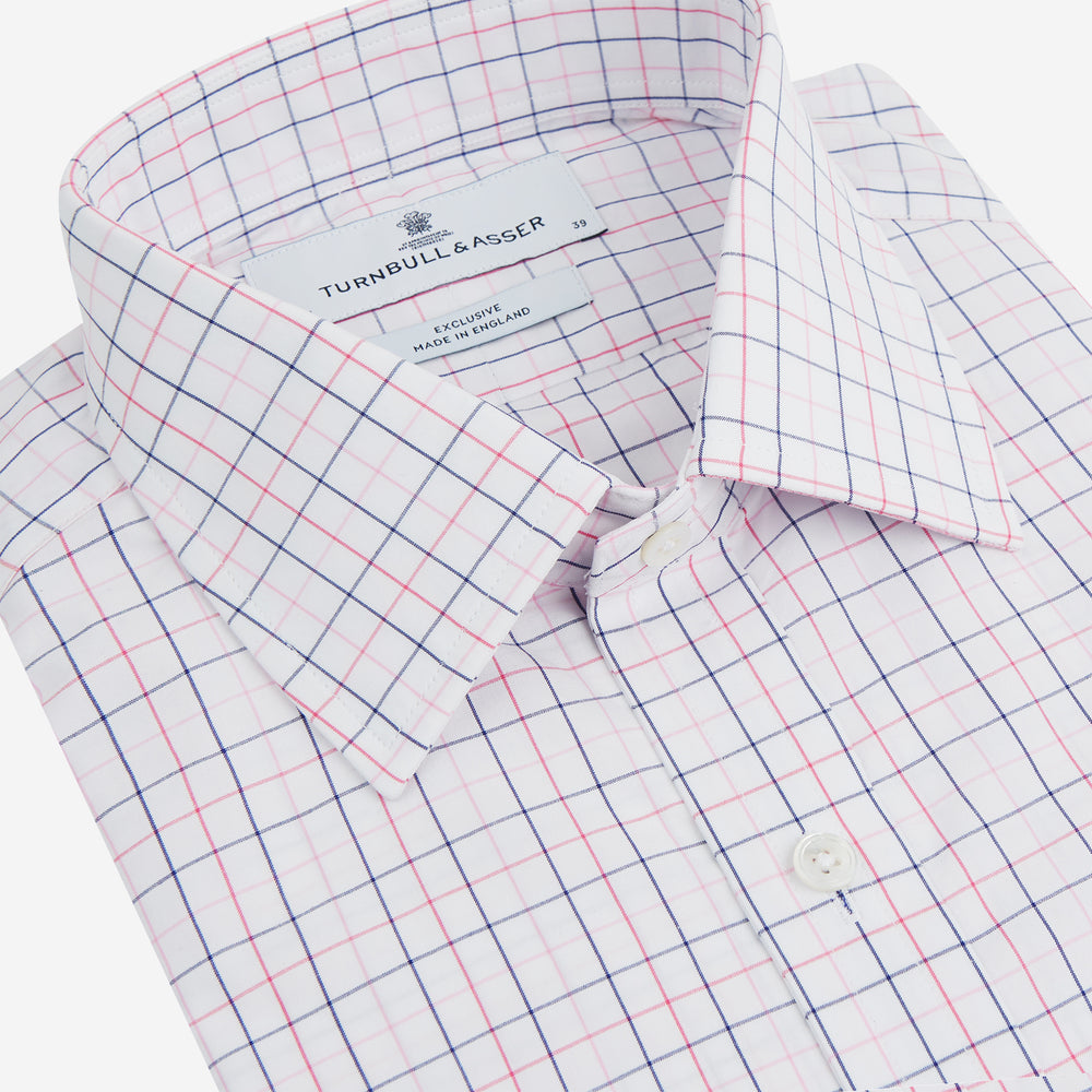 The Turnbull & Asser Pink Overlay Grid Check Mayfair Shirt is a long-sleeved, button-up with a collar and buttoned cuffs, featuring a white base and thin pink grid lines. Laid flat against a white surface.