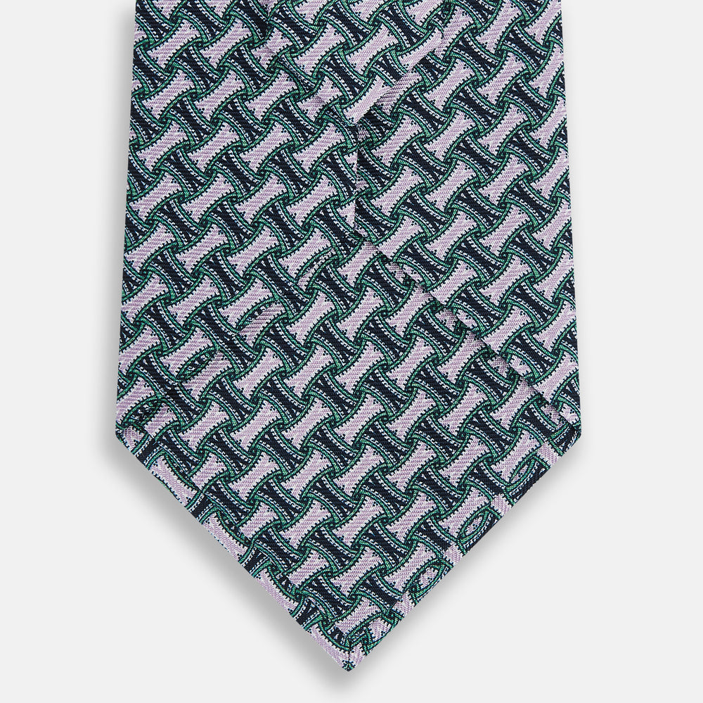 The Turnbull & Asser Lilac and Kelly Weave Patterned Silk Tie, rolled up, showcases a geometric design in lilac and green tones against a plain white background.