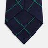 View 4 of product The Turnbull & Asser Green and Navy Window Pane Silk Tie features a subtle ribbed texture with a diagonal green grid pattern, inspired by archival designs—a stylish choice for modern office attire.