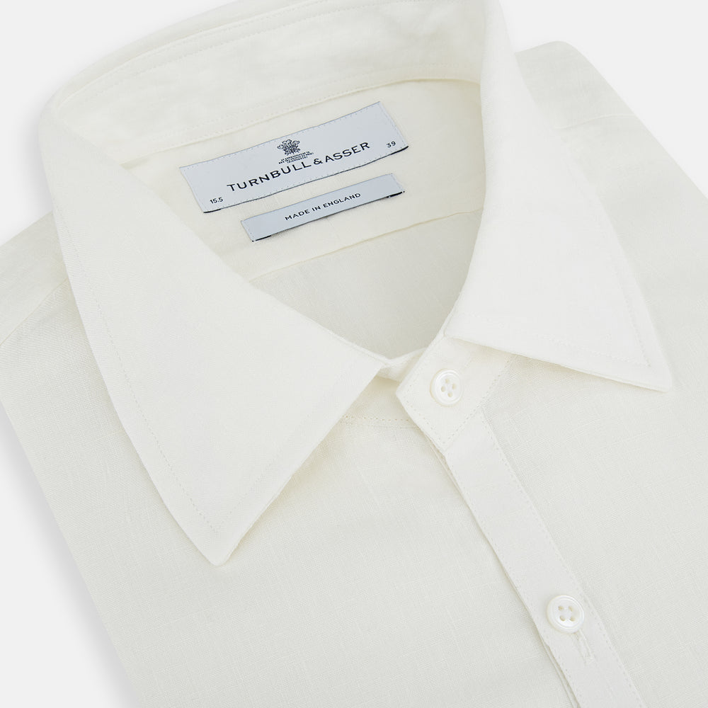 The Vanilla Linen Westminster Shirt by Turnbull & Asser is a long-sleeve, white button-up with a Turnbull collar, buttoned cuffs, and straight hem, highlighting British craftsmanship against a plain white background.
