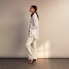 View 11 of product The White Cotton Lauren Shirt by Turnbull & Asser, featuring a stand collar, button-down front, and elongated body, is laid flat on a plain white background.