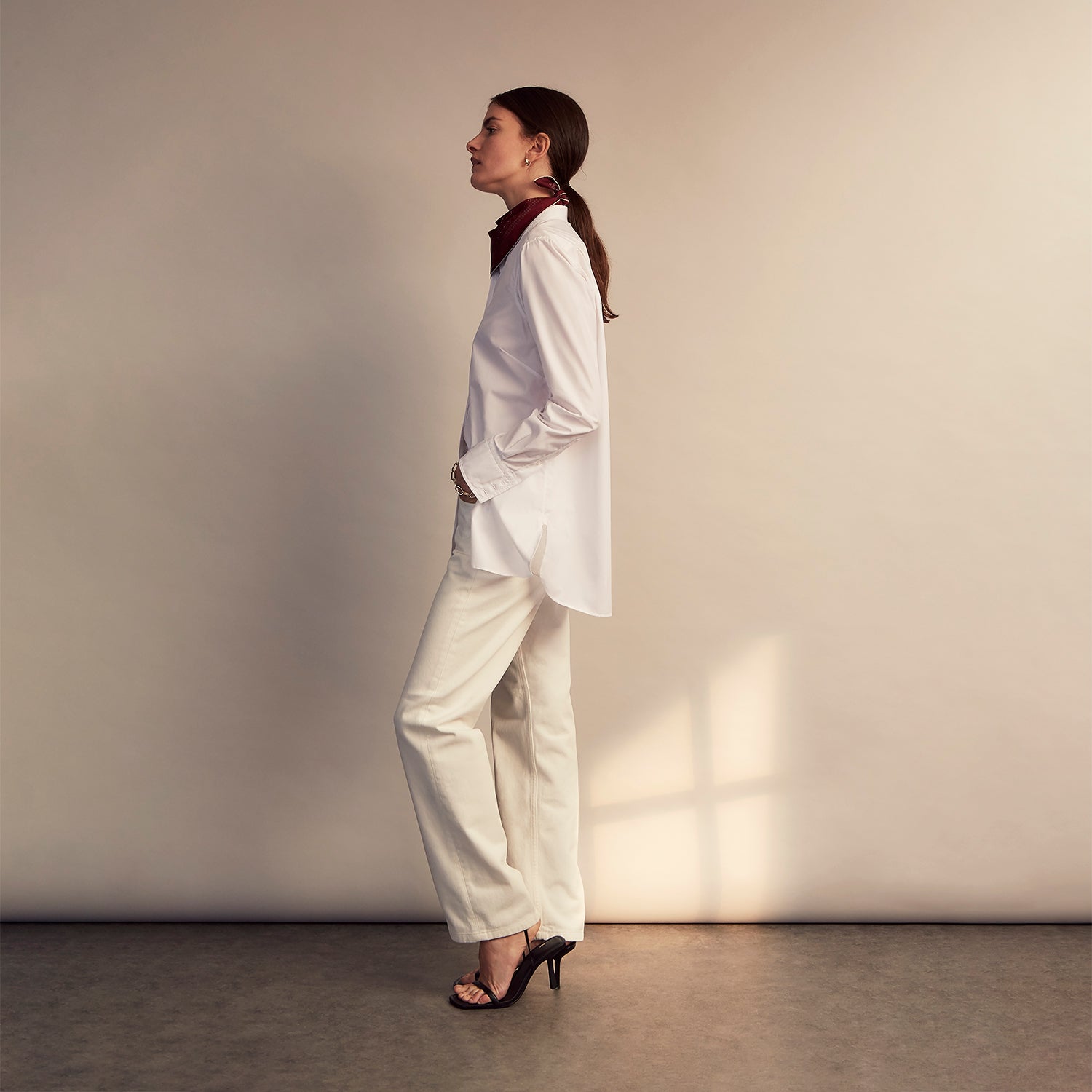 View 11 of product The White Cotton Lauren Shirt by Turnbull & Asser, featuring a stand collar, button-down front, and elongated body, is laid flat on a plain white background.