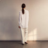 View 4 of product The White Cotton Lauren Shirt by Turnbull & Asser, featuring a stand collar, button-down front, and elongated body, is laid flat on a plain white background.