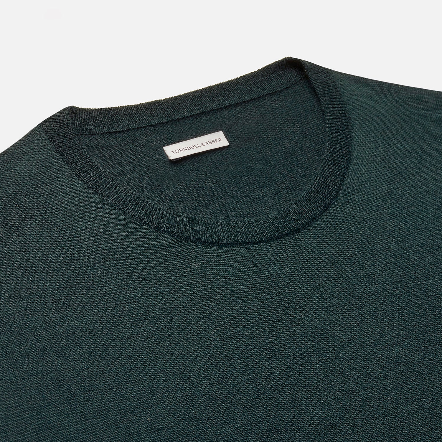 View 2 of product The Turnbull & Asser Forest Green Fine Merino Round Neck Jumper for men is shown on a light gray background. This knitwear features a classic design with ribbed cuffs, hem, and neckline.