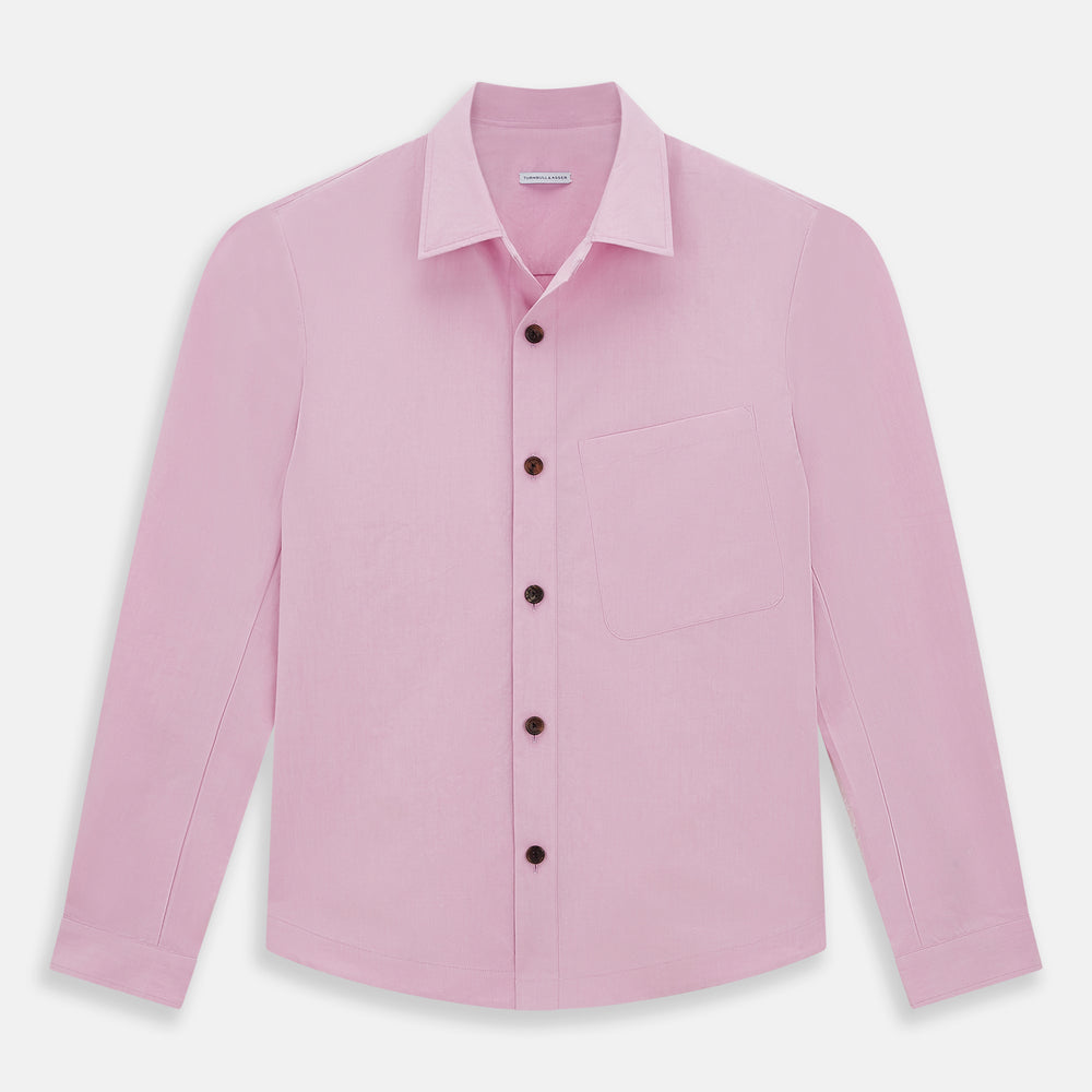 The Pink Hyde Overshirt by Turnbull & Asser is a long-sleeved, light pink sanforised cotton shirt with a left chest pocket and dark buttons—an elegant, laid-back alternative to a blazer.