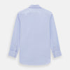 View 3 of product The Turnbull & Asser BLUE HERRINGBONE TAILORED FIT SHIRT WITH KENT COLLAR features long sleeves and buttoned cuffs, offering a timeless formal look in a classic light blue herringbone fabric, laid flat on a white background.