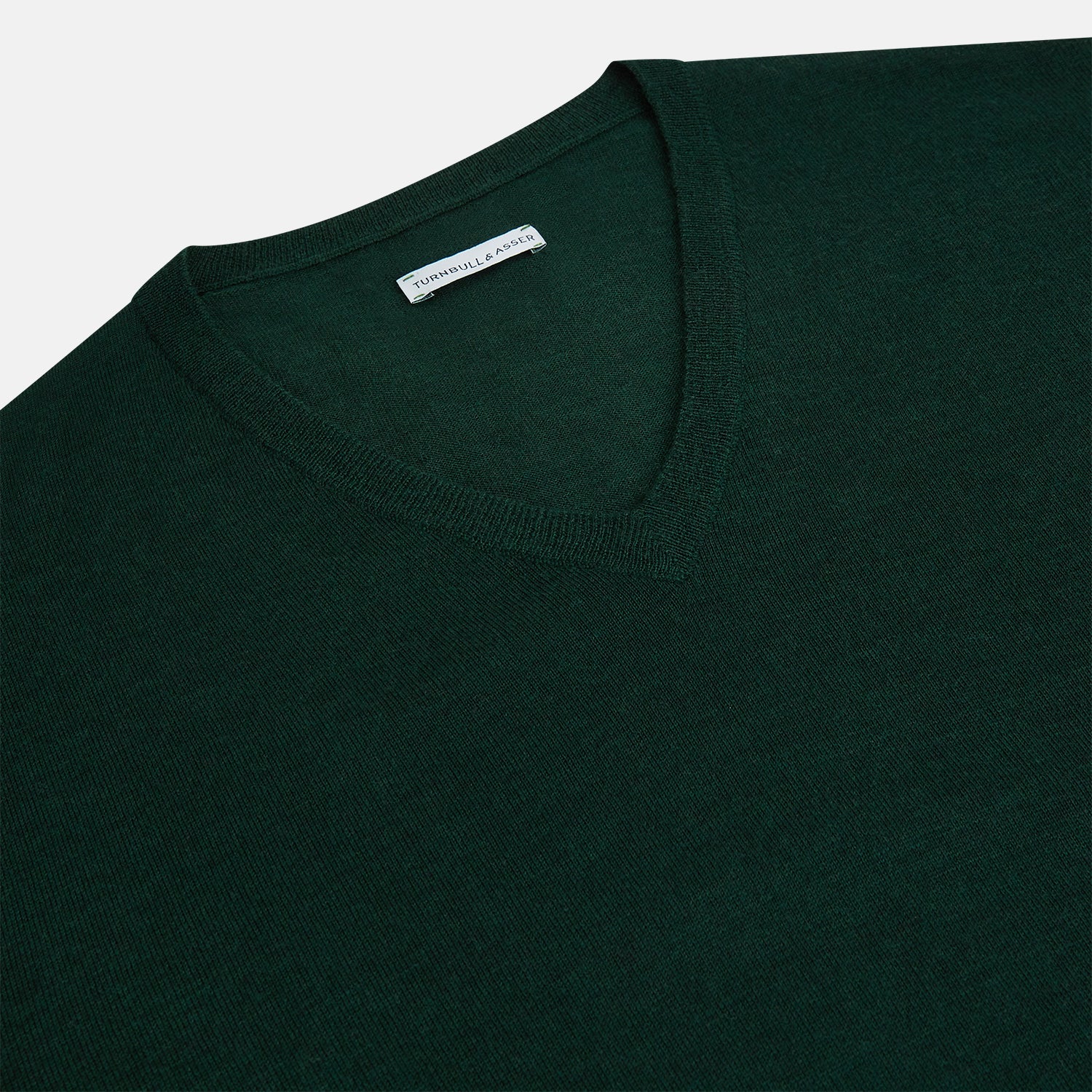 View 2 of product The Turnbull & Asser Petrol Green Merino V-Neck Jumper features long sleeves and ribbed cuffs and hem—an essential knitwear piece, shown against a white background.