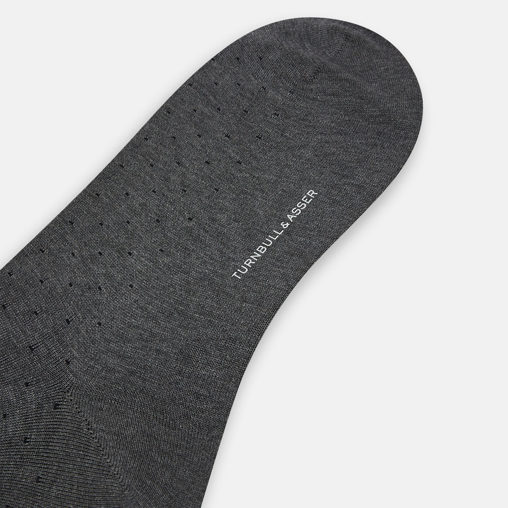 The Turnbull & Asser Steel/midnight Polka Dot Long Sock is shown in dark gray over the calf, displayed from the side on a white background with downward toe and ribbed top for a snug fit.