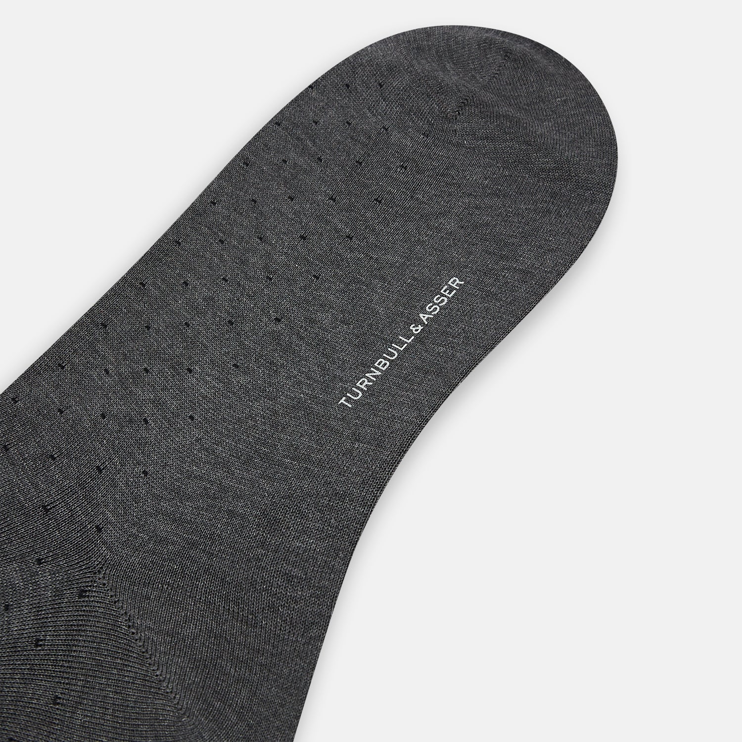 View 3 of product The Turnbull & Asser Steel/midnight Polka Dot Long Sock is shown in dark gray over the calf, displayed from the side on a white background with downward toe and ribbed top for a snug fit.