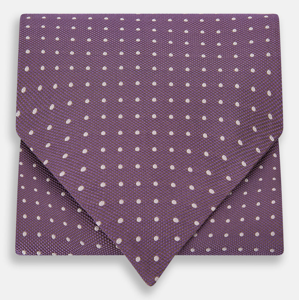 The Lilac and Violet Micro Dot Silk Cravat by Turnbull & Asser features small white polka dots on elegant silk, expertly crafted for a refined look, and is shown against a white background.