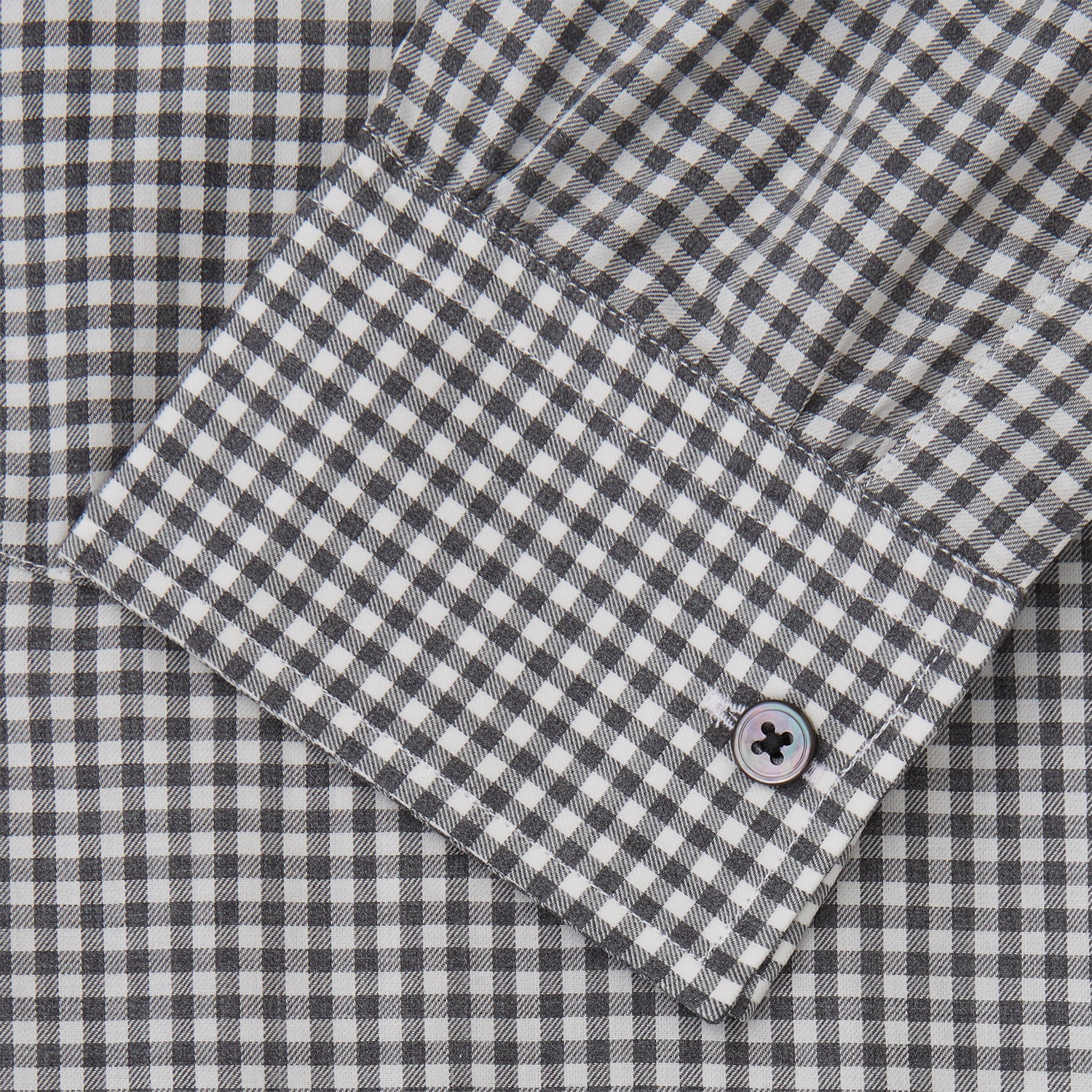 View 4 of product A person with a shaved head models the Turnbull & Asser Grey Check Weekend Fit Flannel Shirt with a Derby collar and 1-button cuffs, sleeves rolled up, paired with dark trousers against a plain background, gazing directly at the camera.
