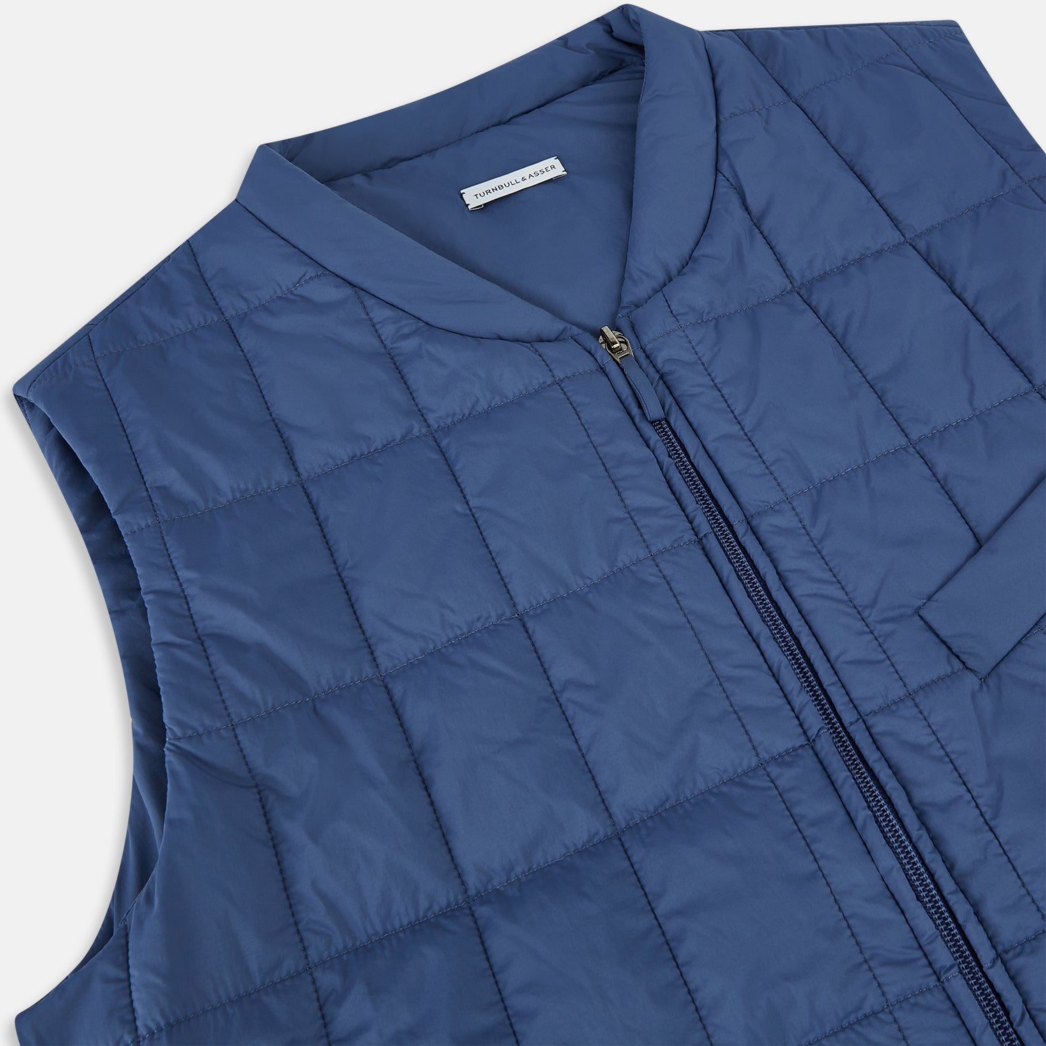 View 2 of product The Azzurro Quilted Gilet by Turnbull & Asser is a sleeveless, lightweight men’s outerwear piece featuring a front zipper, angled zippered pockets, and a chest pocket, shown against a plain white background.