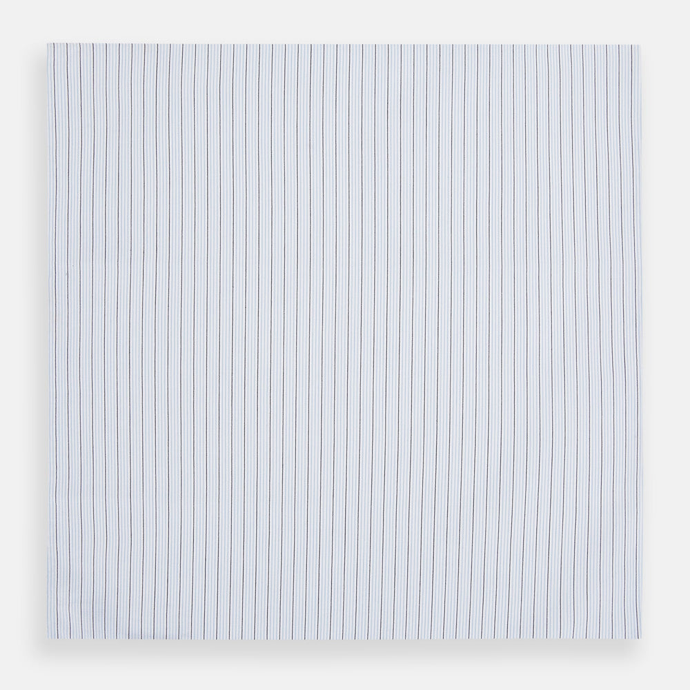 The Turnbull & Asser Hand Rolled Blue Multi Stripe Handkerchief features light blue cotton with thin black and white stripes, making it a refined accessory for the gentleman.