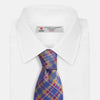 View 4 of product The Turnbull & Asser Blue Multi Tartan Silk Tie features a vibrant blue, yellow, and pink plaid pattern and is shown rolled up on a white background.