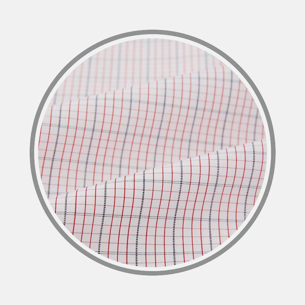 A close-up of Turnbull & Asser's Red Micro Graph Fabric, featuring a white base with thin red and navy blue grid lines, displayed in a circular frame.
