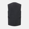 View 3 of product The Turnbull & Asser Ash Quilted Linen Herringbone Waistcoat is sleeveless and dark gray with a V-neck, two zippered side pockets, and a small chest pocket, shown on a plain white background.