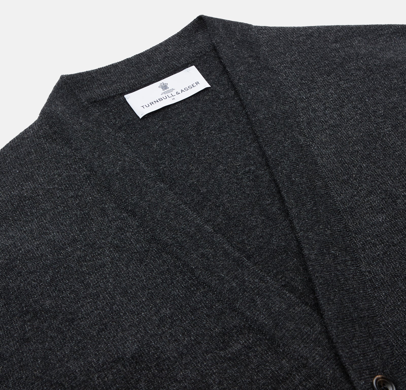 View 2 of product The Turnbull & Asser Charcoal Lachlan Cashmere Cardigan features long sleeves, a V-neck, button-down front, two pockets, and ribbed cuffs—ideal for smart-casual layering—shown laid flat on a white background.
