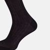 View 4 of product A single Midnight Blue Long Sock by Turnbull & Asser is shown on a white background, showcasing a ribbed texture and a fitted design that extends from the foot to the top of the calf.