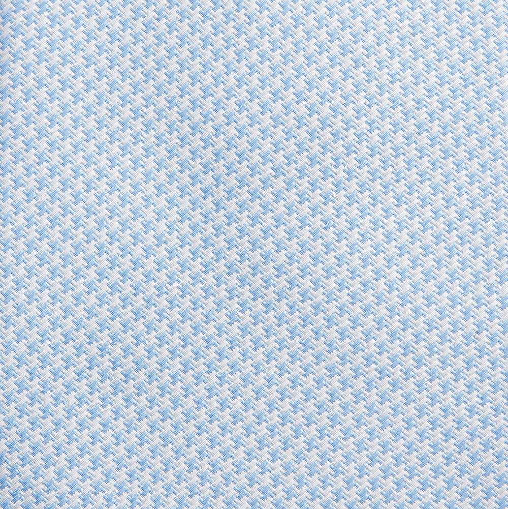 The HOUNDSTOOTH WHITE RIVER TIE by Turnbull & Asser features a light blue and white textured pattern, making it an essential accessory for elegant looks, shown beautifully rolled on a plain white background.