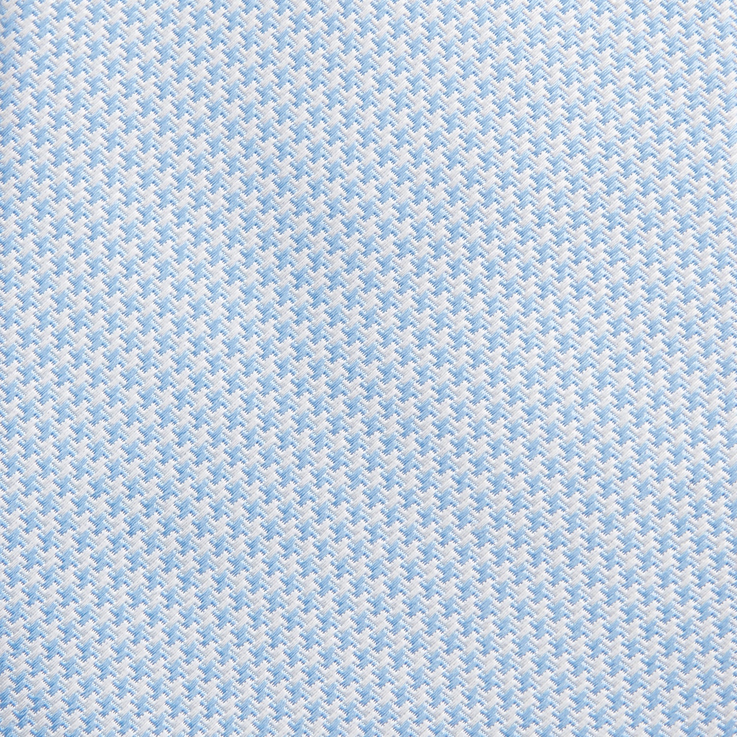 View 2 of product The HOUNDSTOOTH WHITE RIVER TIE by Turnbull & Asser features a light blue and white textured pattern, making it an essential accessory for elegant looks, shown beautifully rolled on a plain white background.