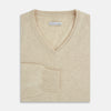 View 4 of product The Turnbull & Asser Ivory Cashmere V-Neck Jumper, with long sleeves and ribbed cuffs and hem, is shown against a plain white background.