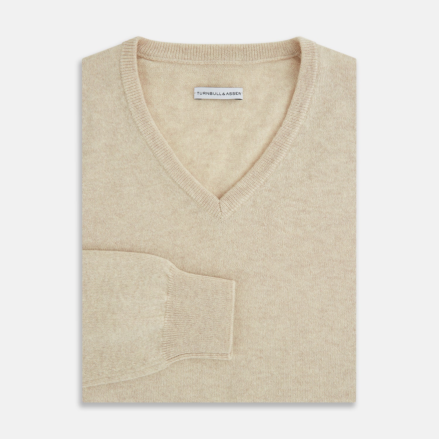 View 4 of product The Turnbull & Asser Ivory Cashmere V-Neck Jumper, with long sleeves and ribbed cuffs and hem, is shown against a plain white background.