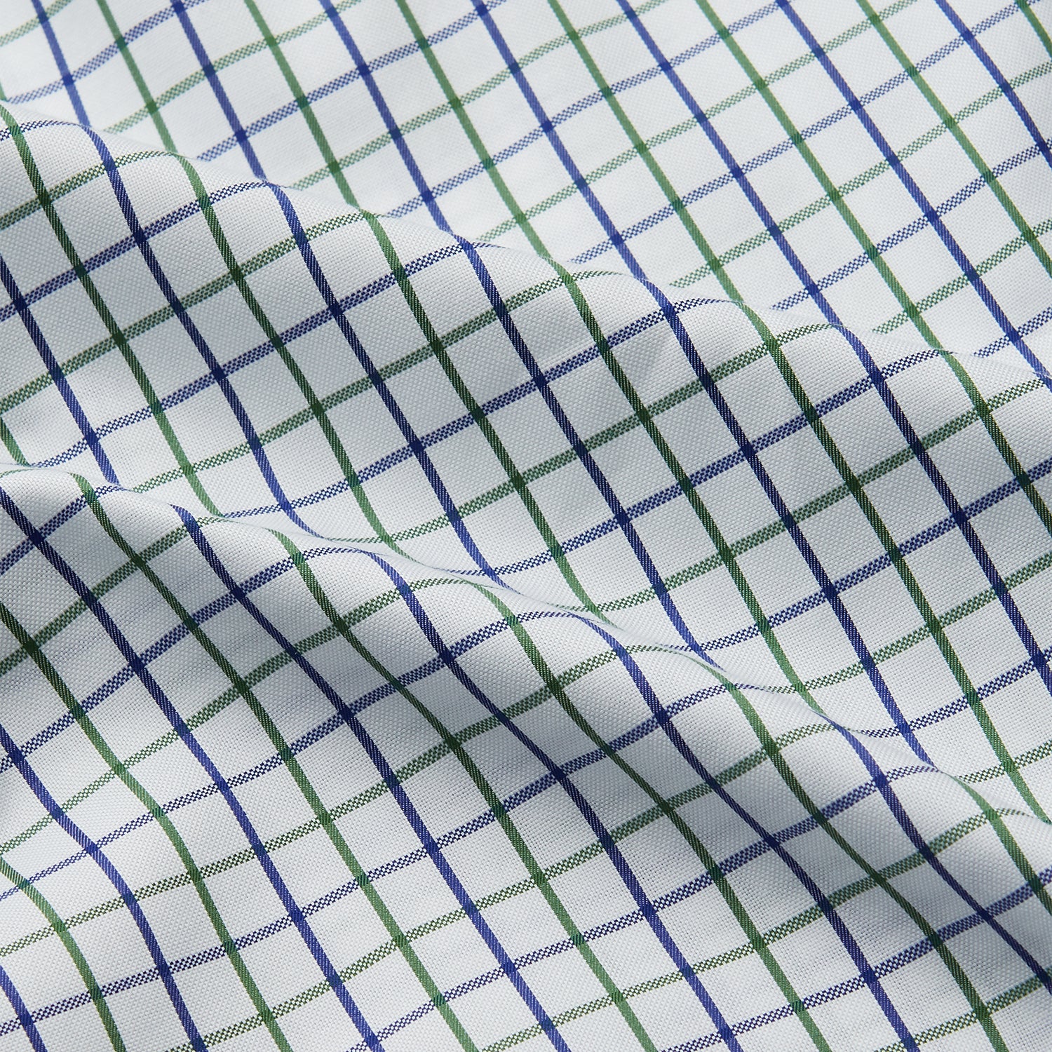 View 4 of product The Turnbull & Asser Green and Blue Check Cotton Hyde Pyjama Set for men features a long-sleeve, button-up top and pants with contrasting dark piping, shown laid flat on a white background.