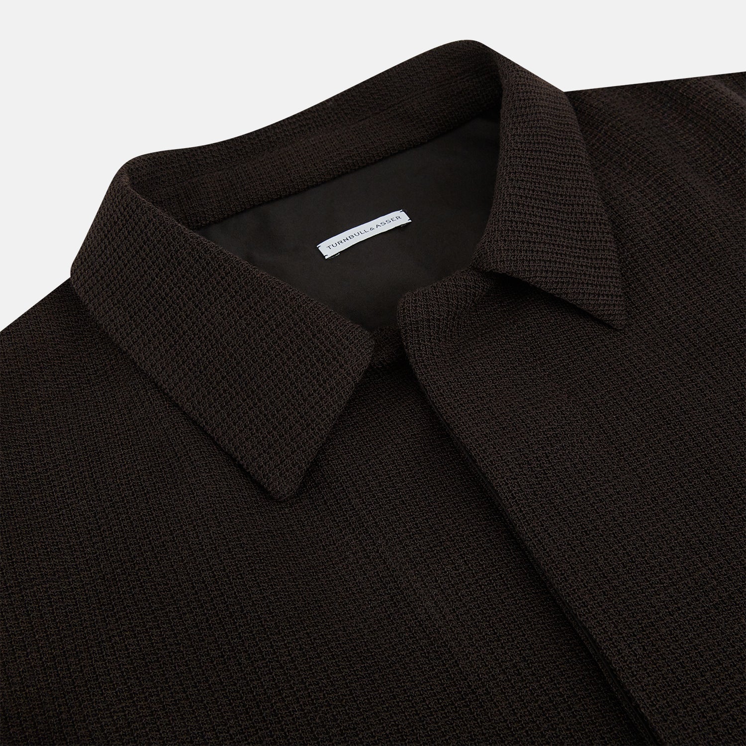 View 2 of product The Turnbull & Asser Dark Chocolate Greenwich Knitted Overshirt is crafted from Italian wool, with a classic collar, two flap chest pockets, and a concealed button front—offering a sleek cardigan alternative. Shown on a white background.