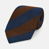 View 1 of product A close-up of the Turnbull & Asser Brown and Navy Block Stripe Silk Tie displays its textured pattern with classic suiting diagonal stripes in navy blue and brown on a light background.