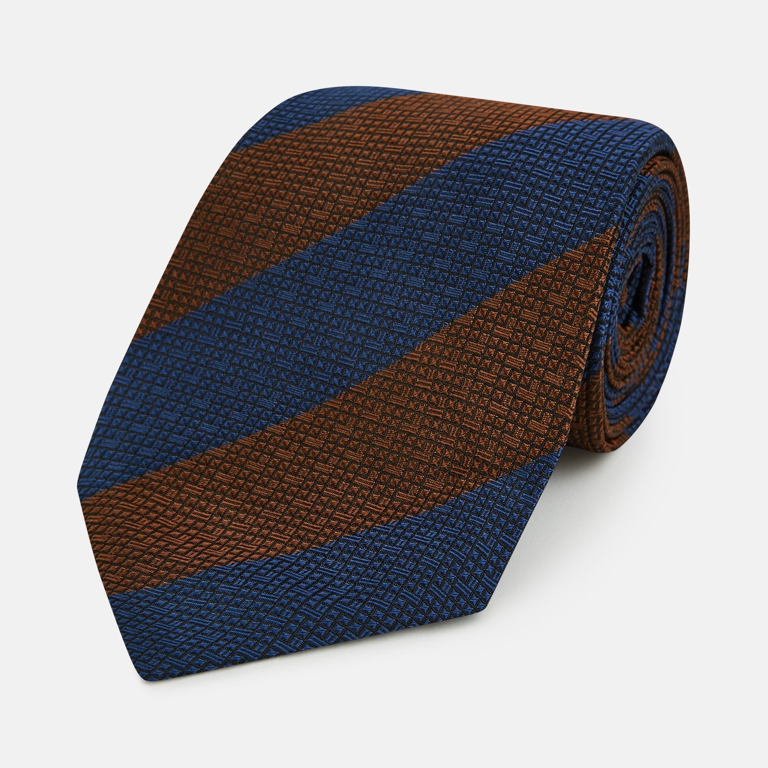 View 1 of product A close-up of the Turnbull & Asser Brown and Navy Block Stripe Silk Tie displays its textured pattern with classic suiting diagonal stripes in navy blue and brown on a light background.