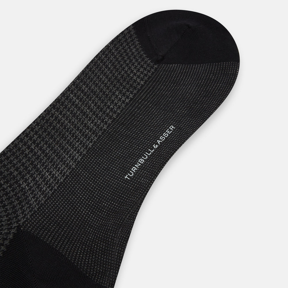 The Turnbull & Asser Charcoal Melange Houndstooth Mid-Length Sock features a black toe, heel, and cuff, and is shown singly against a plain white background.