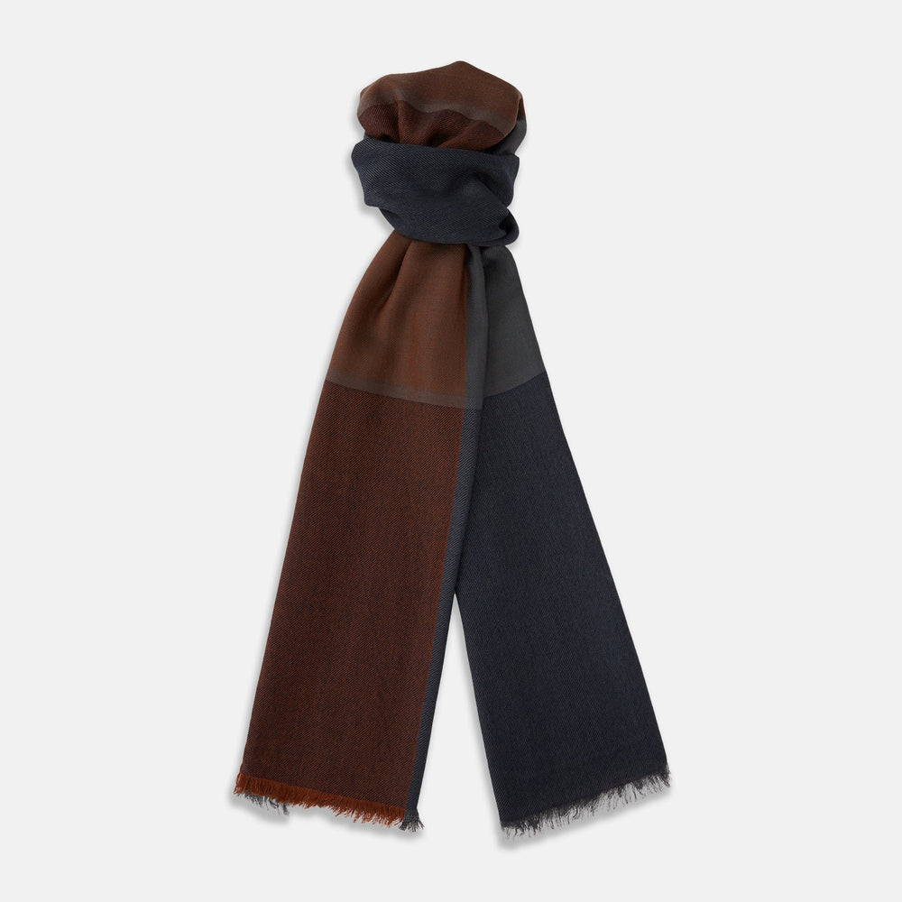 The Turnbull & Asser Brown and Navy Cashmere Scarf features a long, rectangular shape, color block design, soft texture, and lightly frayed edges, elegantly folded on a plain white background.