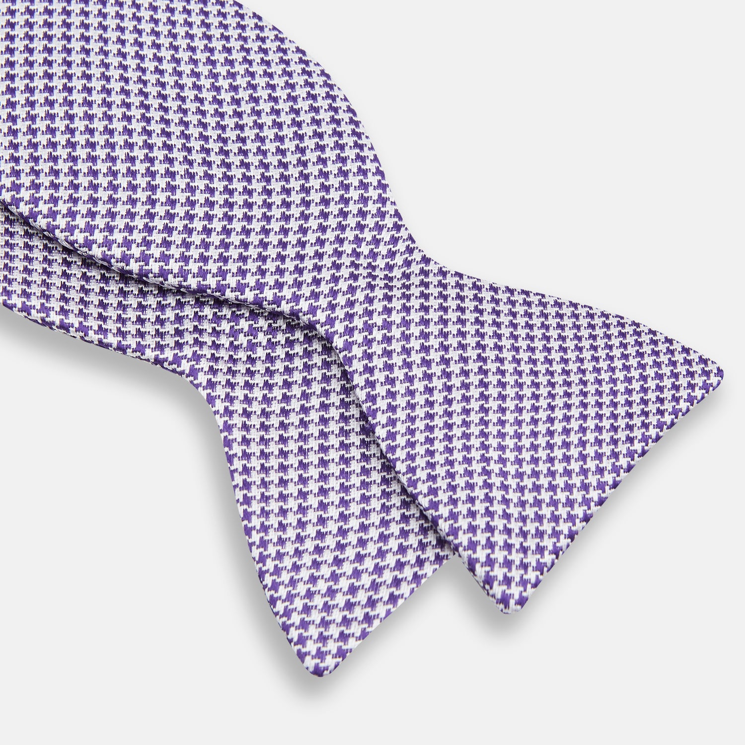 View 3 of product The Turnbull & Asser Purple and White Houndstooth Silk Bow Tie, ideal for formalwear, is shown against a white background.