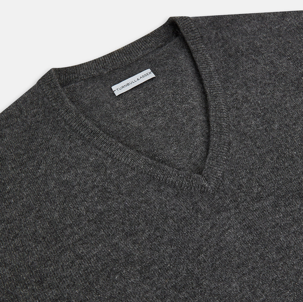 The Charcoal Grey Cashmere V-neck Jumper by Turnbull & Asser features ribbed cuffs, hem, and neckline—an essential knitwear piece, shown on a white background.