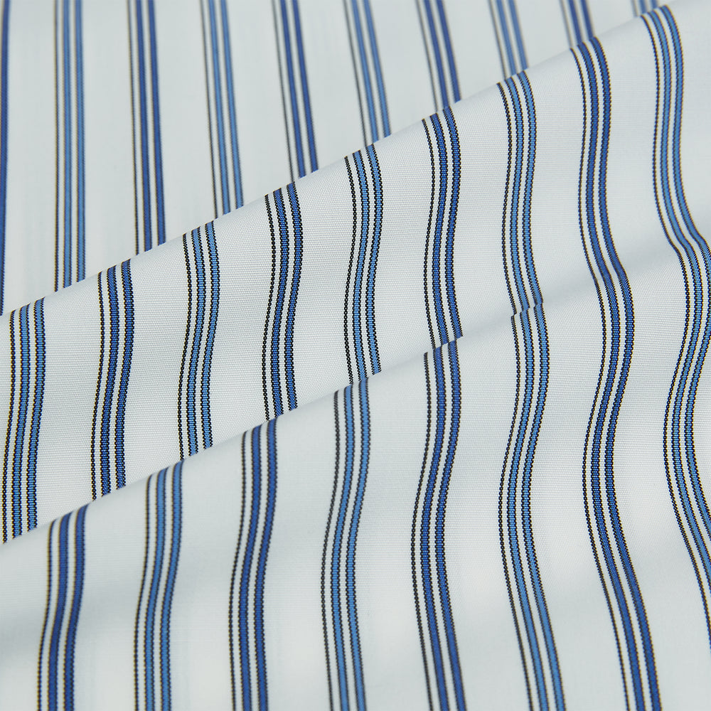The SAPPHIRE BLUE MULTI TRACK STRIPE WINDSOR SHIRT by Turnbull & Asser features long sleeves, button-up front, classic collar, blue and white vertical stripes, buttoned cuffs, and showcases British craftsmanship on a white background.
