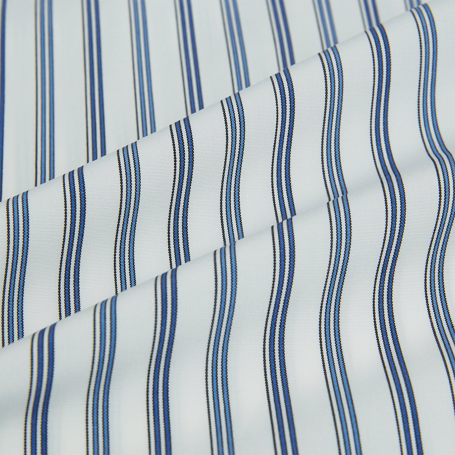 View 8 of product The SAPPHIRE BLUE MULTI TRACK STRIPE WINDSOR SHIRT by Turnbull & Asser features long sleeves, button-up front, classic collar, blue and white vertical stripes, buttoned cuffs, and showcases British craftsmanship on a white background.