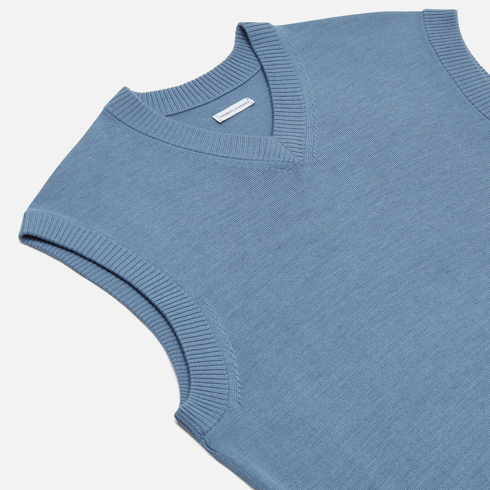 The Turnbull & Asser Pale Blue Fine Merino V-Neck Vest features a sleeveless design, knit texture, and classic V-neckline, shown against a plain white background.