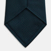 View 4 of product The Turnbull & Asser Navy Houndstooth Forest Green Tie is shown rolled up, featuring a subtle houndstooth pattern against a plain white background.