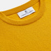View 2 of product The Gold Glenn Cashmere Crew Neck Jumper by Turnbull & Asser is a luxurious, long-sleeved knit in vibrant mustard yellow, shown laid flat on a white background—an eye-catching essential.