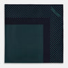 View 4 of product The Turnbull & Asser Navy and Petrol Green Dot Silk Pocket Square features handmade craftsmanship with petrol green polka dots and a darker border, elegantly displayed on a white background.