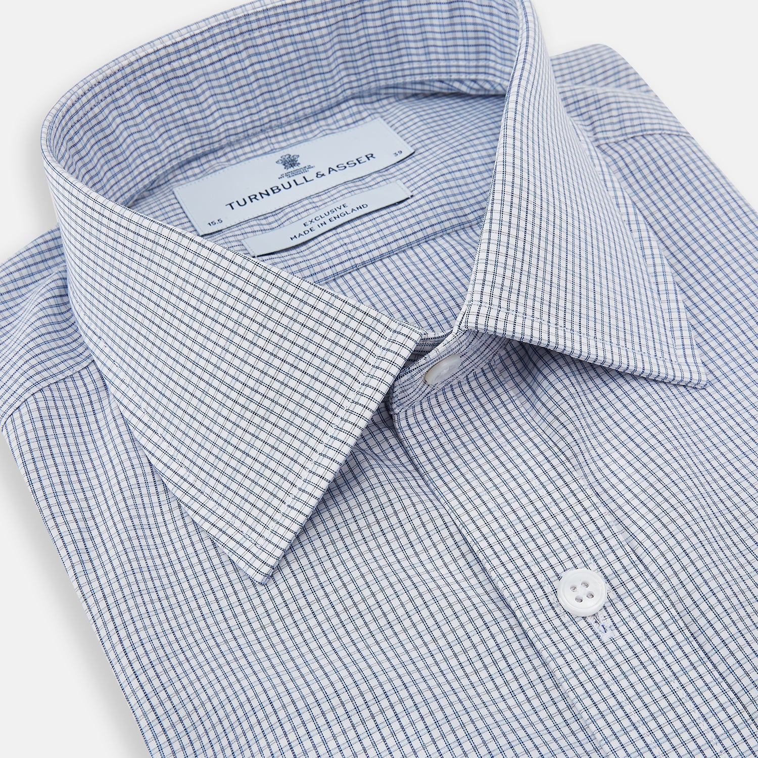 View 2 of product The Turnbull & Asser Blue Micro Graph Check Mayfair Shirt features long sleeves, a subtle check pattern, T&A collar, and buttoned cuffs, shown laid flat on a white background.