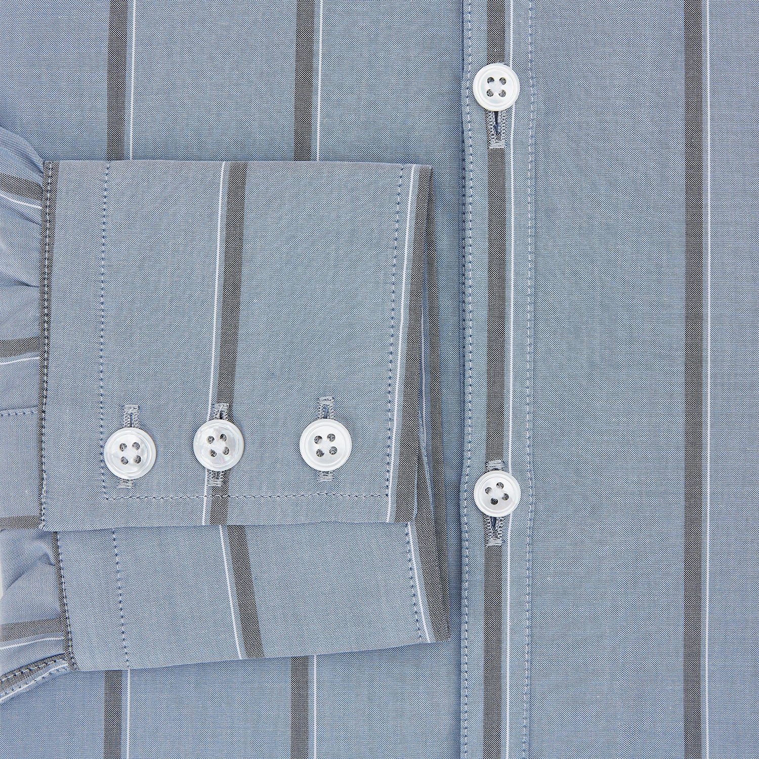 View 4 of product The Steel Blue Track Stripe Westminster Shirt by Turnbull & Asser features dark pinstripes, a classic collar, white buttons, and buttoned cuffs—expertly crafted to highlight British craftsmanship. Laid flat on white background.