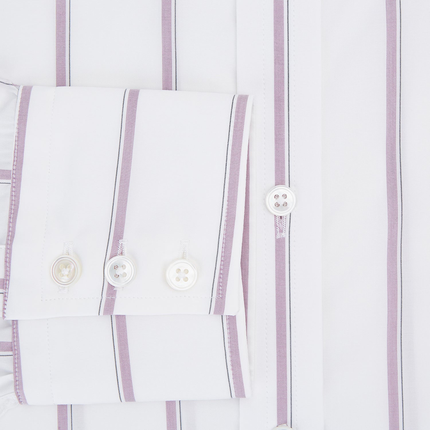 View 4 of product The Turnbull & Asser Antique Pink Track Stripe Mayfair Shirt is a white, long-sleeved Italian cotton shirt with vertical pink stripes, a spread collar, and buttoned cuffs, shown laid flat on a white background.