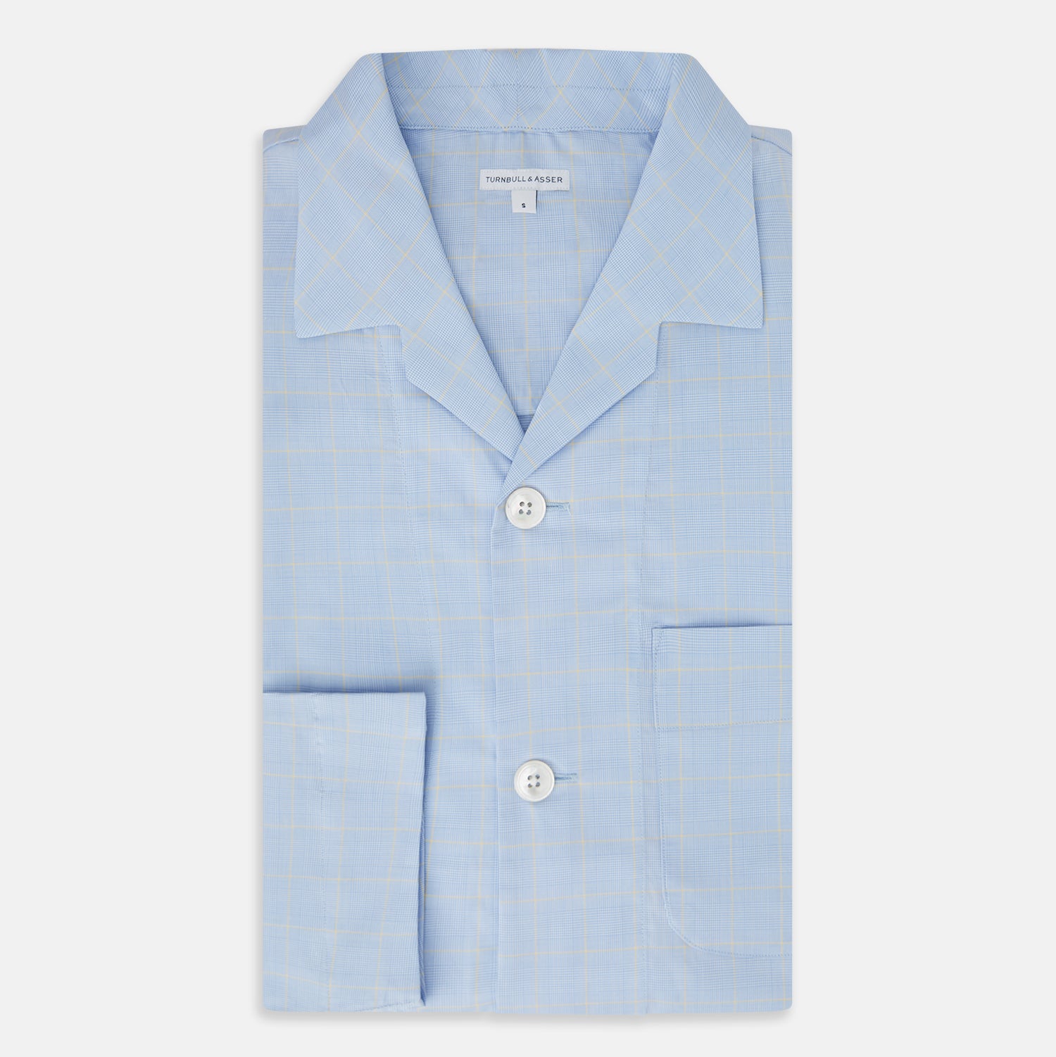 View 5 of product The Turnbull & Asser Blue Prince of Wales Check Pyjama Shirt features long sleeves, a notched collar, a left chest pocket, and a subtle check pattern, shown laid flat on a white background.
