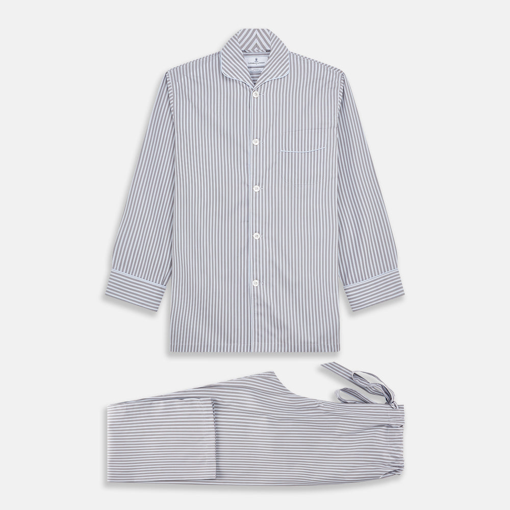 The Turnbull & Asser Pale Blue Multi Stripe Cotton Quin Pyjamas, featuring a long-sleeve button-up top and matching adjustable tie-waist pants, are neatly arranged on a white background.