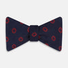 View 1 of product Elevate your formalwear with the Turnbull & Asser Navy and Burgundy Motif Silk Bow Tie, featuring a subtle ribbed texture and repeating red geometric motifs.